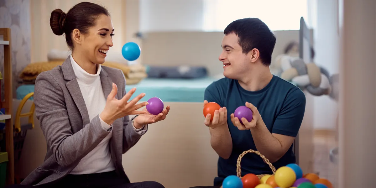 enfant handicapé avec une femme qui jonglent avec des balles